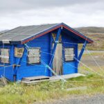 blue and white wooden house on green grass field during daytime